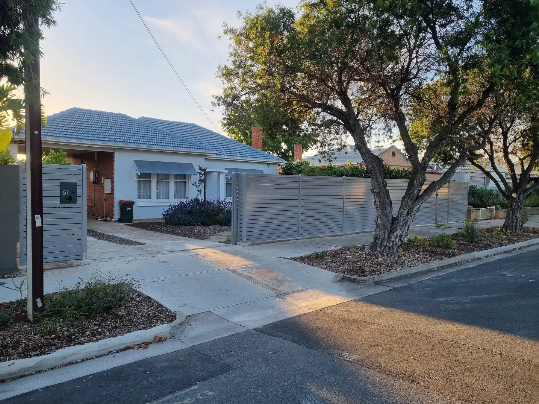 Grey aluminium slat gate and front fence on a suburban street