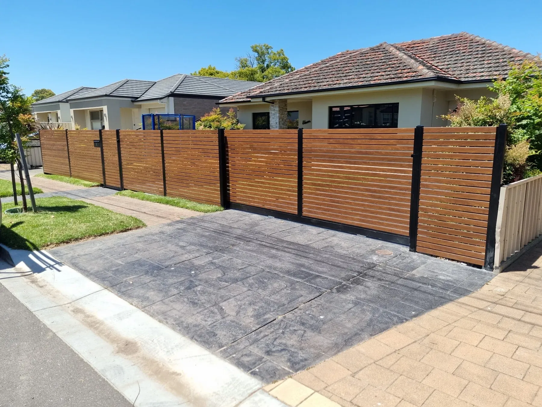 Timber-look aluminium slat sliding gate and front fence