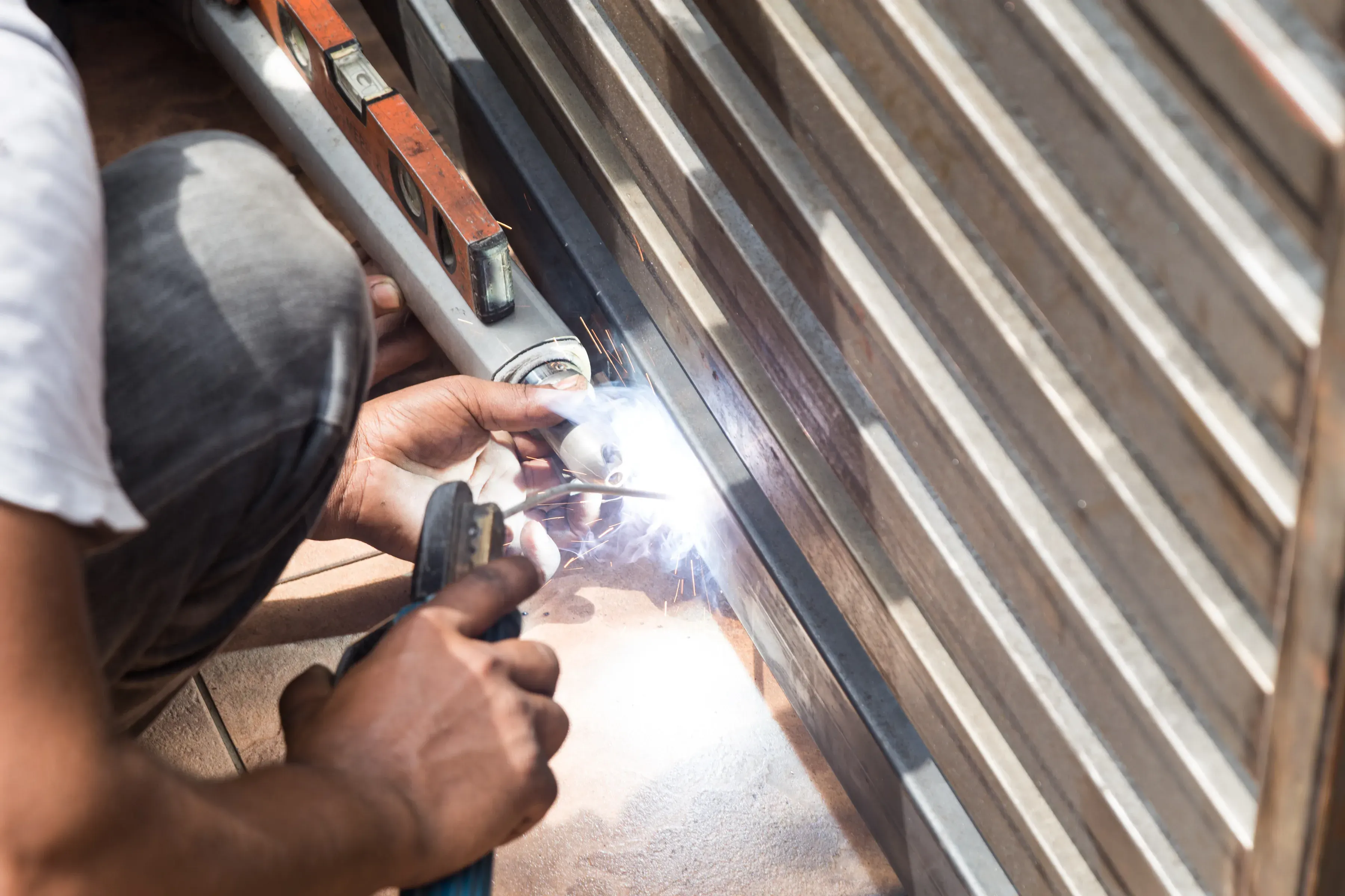 Technician welding an automatic gate during a repair