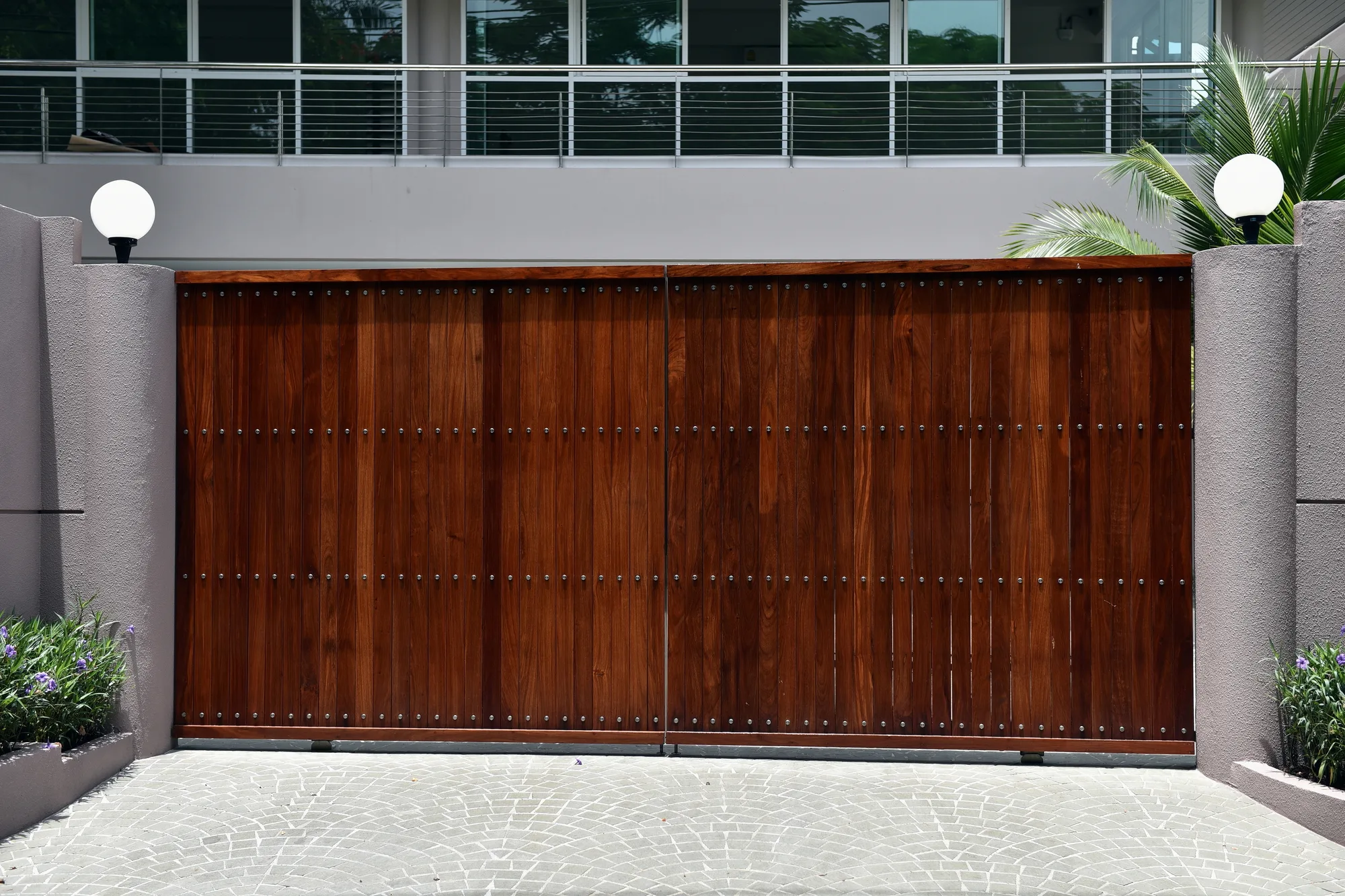 Timber automatic swing gates between rendered pillars